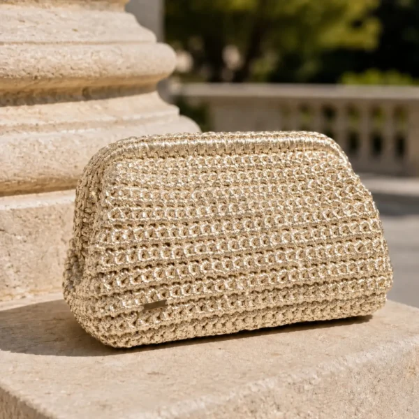 Bolso de mano dorado Melek en crochet metalizado artesanal sobre piedra clara.