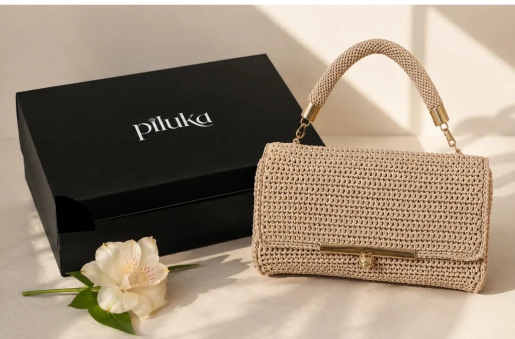 Bolso de crochet claro junto a caja negra de Piluka.